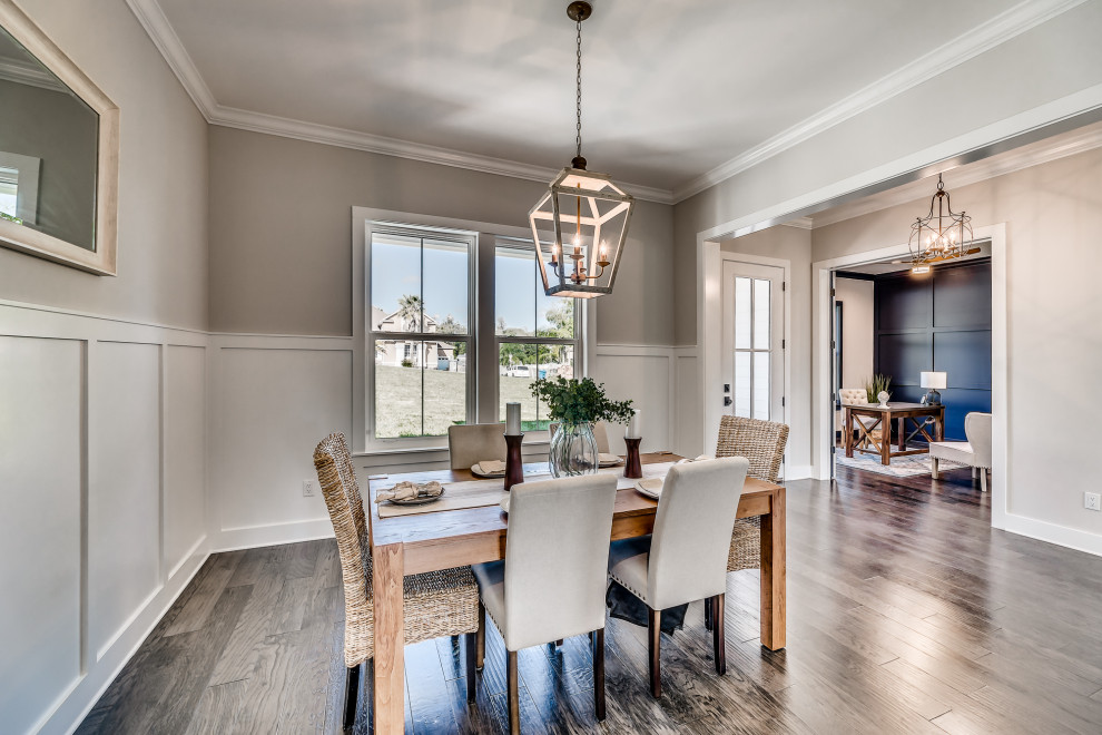 This is an example of a mid-sized country separate dining room in Jacksonville with grey walls, medium hardwood floors and brown floor.