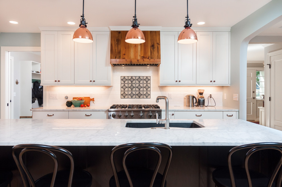 Inspiration for a mid-sized transitional l-shaped light wood floor open concept kitchen remodel in Detroit with an undermount sink, recessed-panel cabinets, white cabinets, quartzite countertops, white backsplash, subway tile backsplash, stainless steel appliances and an island