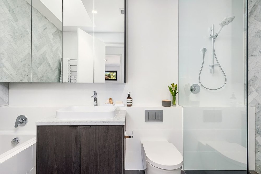 Design ideas for a contemporary bathroom in Sydney with flat-panel cabinets, black cabinets, a corner tub, a corner shower, a one-piece toilet, gray tile, white walls, a console sink, engineered quartz benchtops, grey floor, an open shower, white benchtops, a single vanity and a floating vanity.