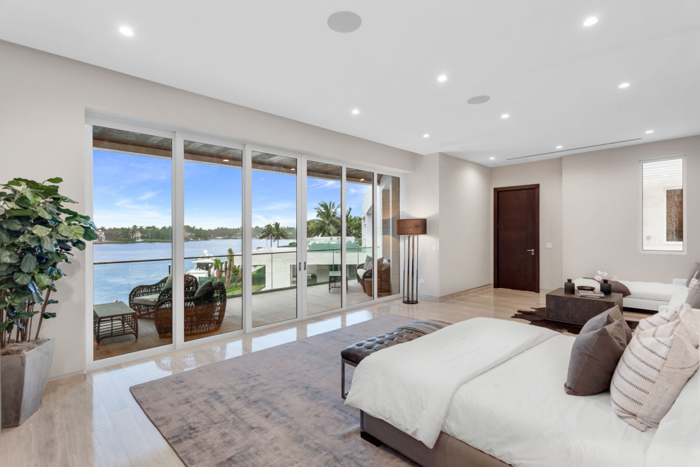 Photo of a large modern master bedroom in Miami with grey walls, travertine floors and grey floor.
