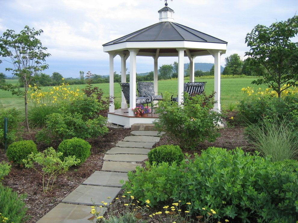 Large traditional backyard patio in Burlington with a gazebo/cabana and natural stone pavers.