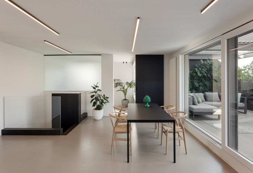 Expansive open plan dining in Milan with white walls, concrete floors, a ribbon fireplace, a metal fireplace surround, grey floor and recessed.
