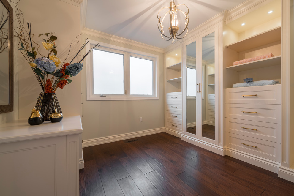 Design ideas for a large transitional gender-neutral walk-in wardrobe in Toronto with recessed-panel cabinets, white cabinets, dark hardwood floors and brown floor.