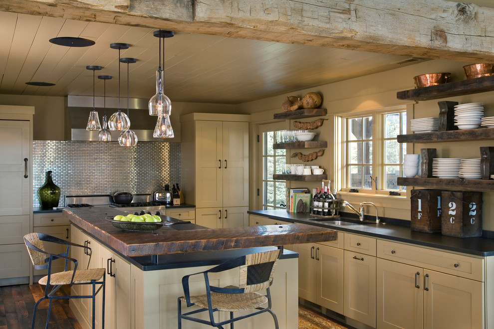 Inspiration for a mid-sized country l-shaped eat-in kitchen in Other with an undermount sink, flat-panel cabinets, beige cabinets, wood benchtops, metallic splashback, metal splashback, stainless steel appliances, with island and dark hardwood floors.