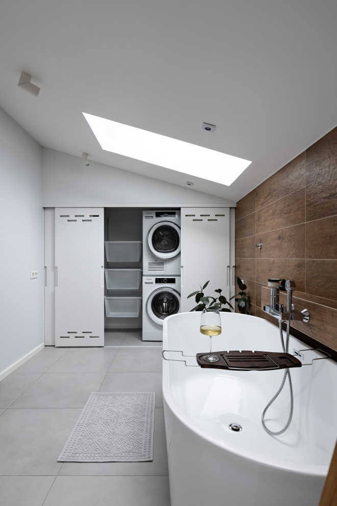 Idee per una stanza da bagno nordica di medie dimensioni con vasca freestanding, piastrelle marroni, piastrelle in gres porcellanato, pavimento in gres porcellanato e pavimento grigio