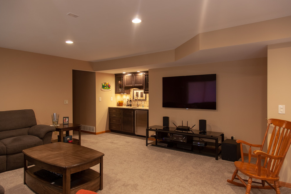 Basement - large transitional walk-out carpeted and beige floor basement idea in Cincinnati with beige walls, a standard fireplace and a brick fireplace