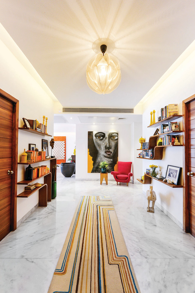 Large contemporary hallway in Mumbai with white walls, marble floors and white floor.