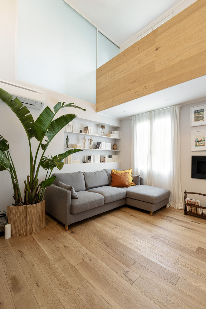 Großes, Offenes Nordisches Wohnzimmer mit weißer Wandfarbe und hellem Holzboden in Mailand