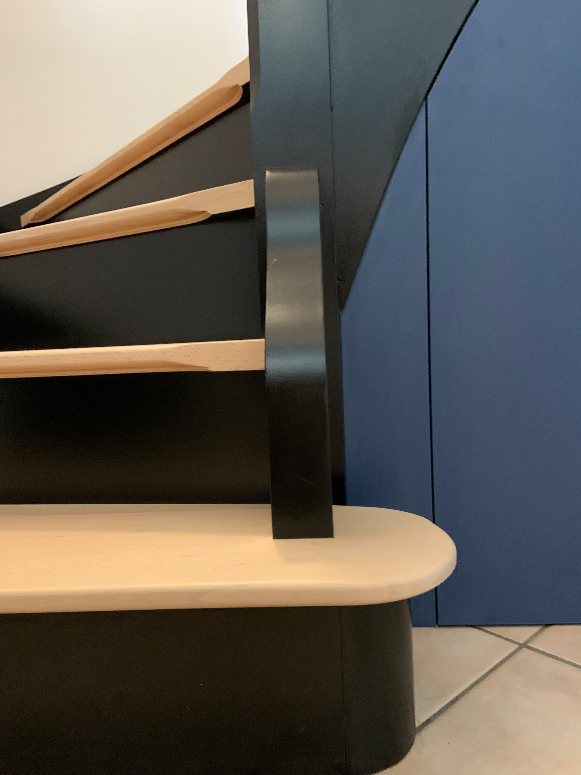 Intégration d'un mobilier sur mesure sous l'escalier pour créer des rangements et exploiter l'espace.