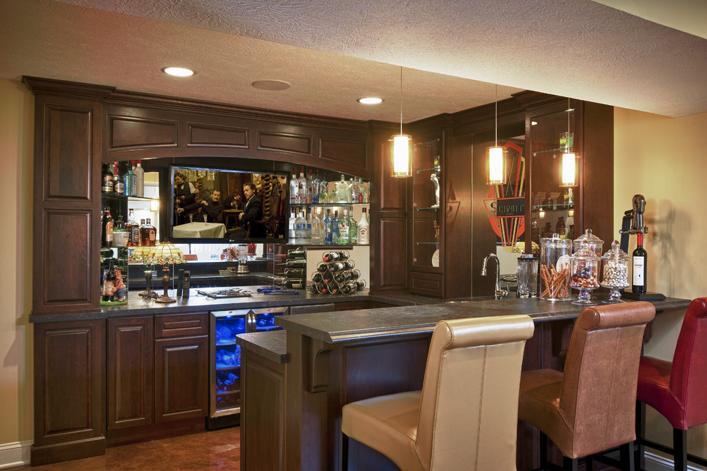 This is an example of a large traditional home bar in Cleveland with concrete floors and brown floor.
