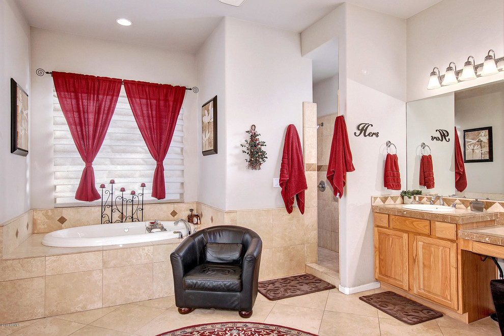 This is an example of a large master bathroom in Phoenix with a drop-in tub, an alcove shower, beige tile, white walls and travertine floors.