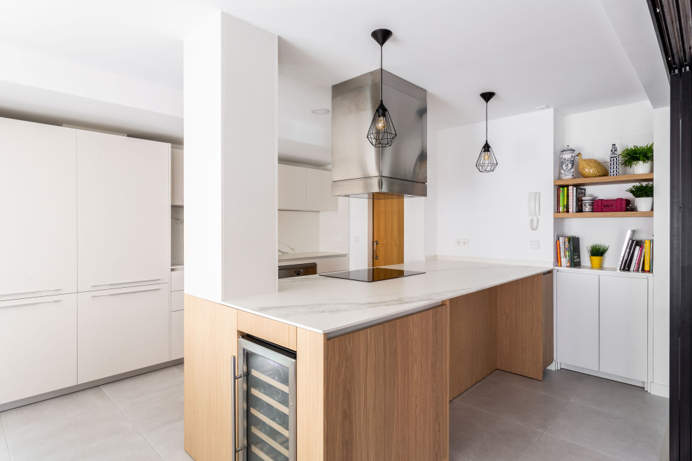 Design ideas for a large modern single-wall open plan kitchen in Madrid with a submerged sink, flat-panel cabinets, light wood cabinets, marble worktops, white splashback, marble splashback, integrated appliances, cement flooring, an island, grey floors and white worktops.