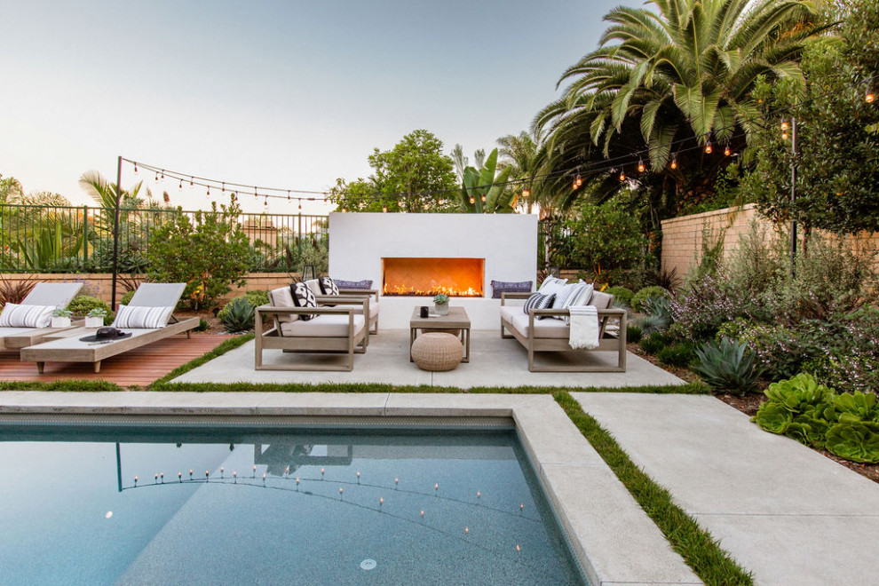 Photo of a mid-sized contemporary garden in Orange County with with fireplace and concrete pavers.