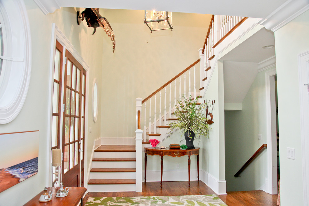 Photo of a beach style entryway in Other with green walls, dark hardwood floors and a dark wood front door.