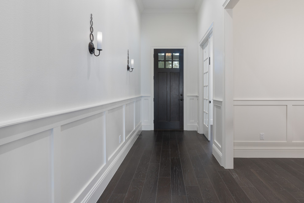 This is an example of a large arts and crafts foyer in Orlando with white walls, dark hardwood floors, a single front door and a dark wood front door.