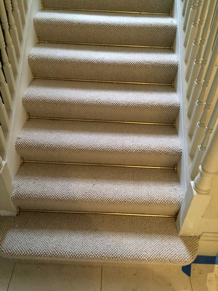 Design ideas for a mid-sized transitional carpeted u-shaped staircase in London with carpet risers and wood railing.