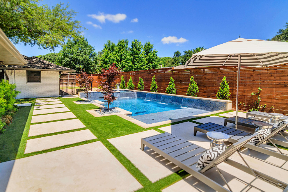 Photo of a contemporary pool in Dallas with a water feature.