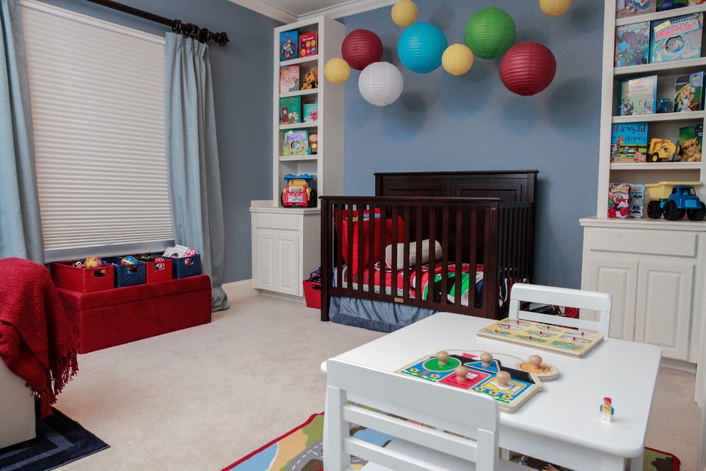 Inspiration for a large traditional nursery for boys in Charlotte with blue walls and carpet.