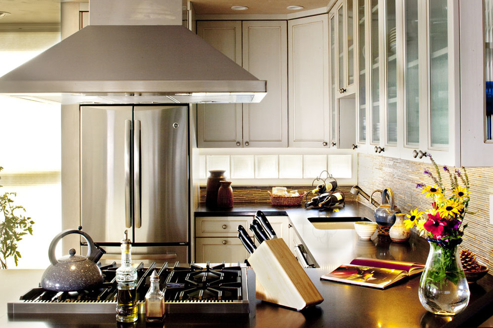 Example of a mid-sized transitional u-shaped light wood floor open concept kitchen design in Denver with an undermount sink, recessed-panel cabinets, gray cabinets, granite countertops, multicolored backsplash, mosaic tile backsplash, stainless steel appliances and a peninsula
