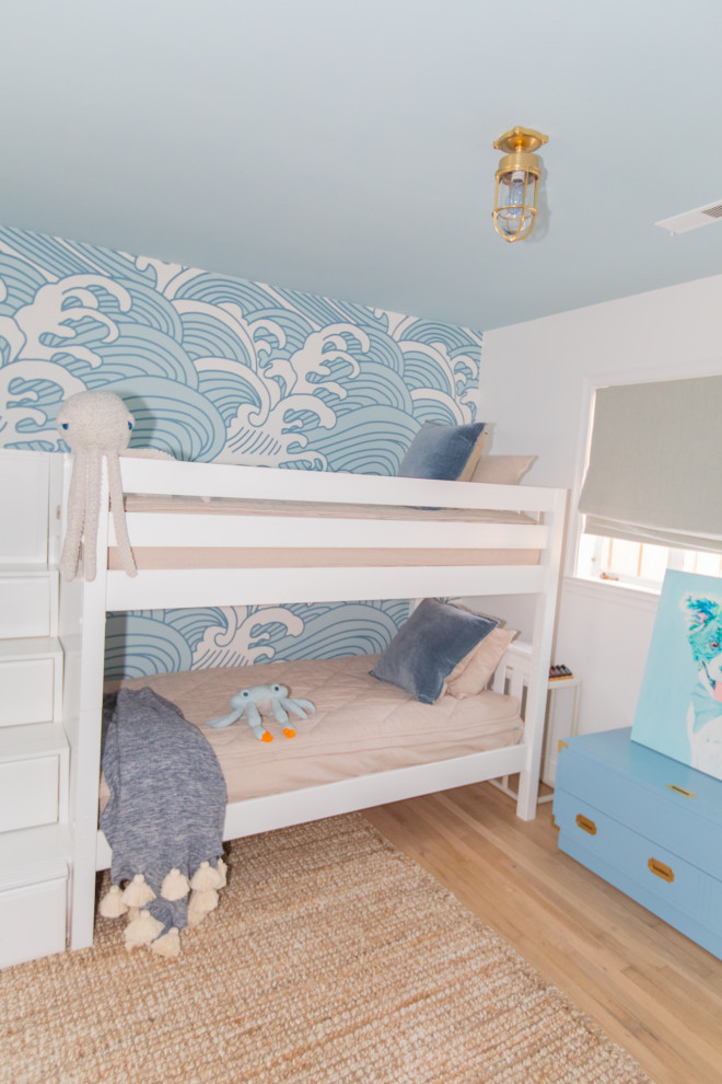 На фото: большая нейтральная детская в морском стиле с спальным местом, синими стенами, светлым паркетным полом и обоями на стенах для ребенка от 4 до 10 лет с