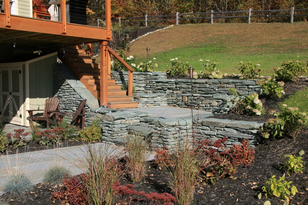 Mid-sized country backyard patio in Burlington with natural stone pavers.
