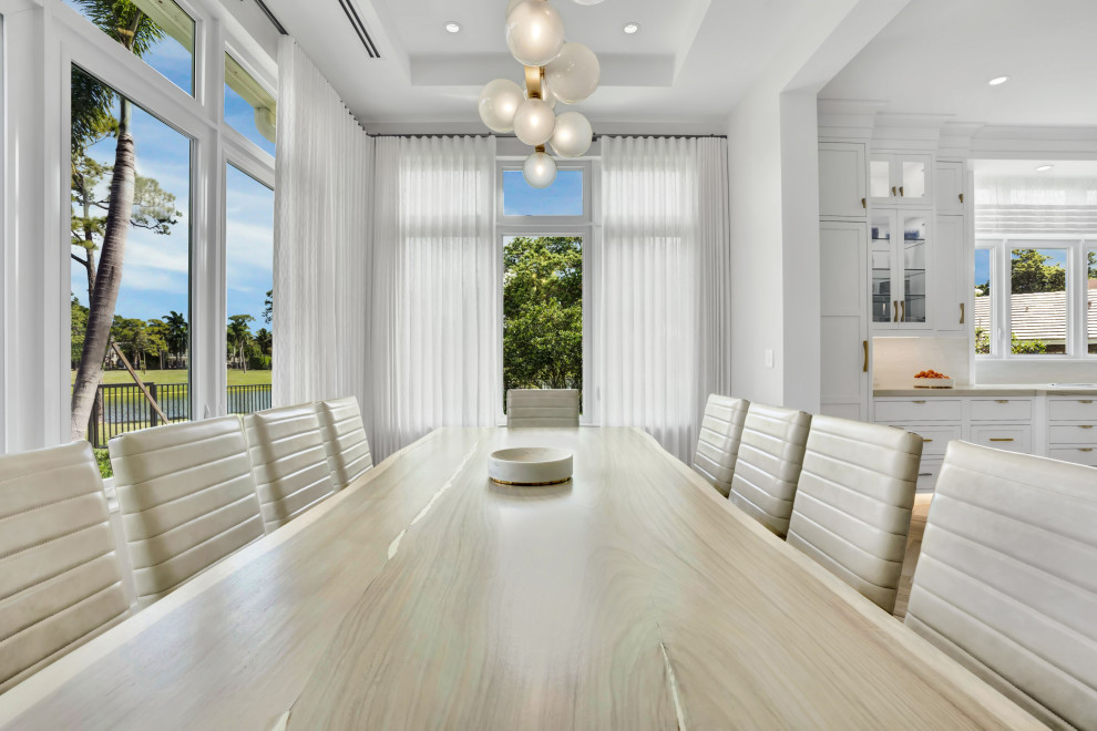Large contemporary kitchen/dining combo in Miami with beige walls, medium hardwood floors, beige floor and recessed.