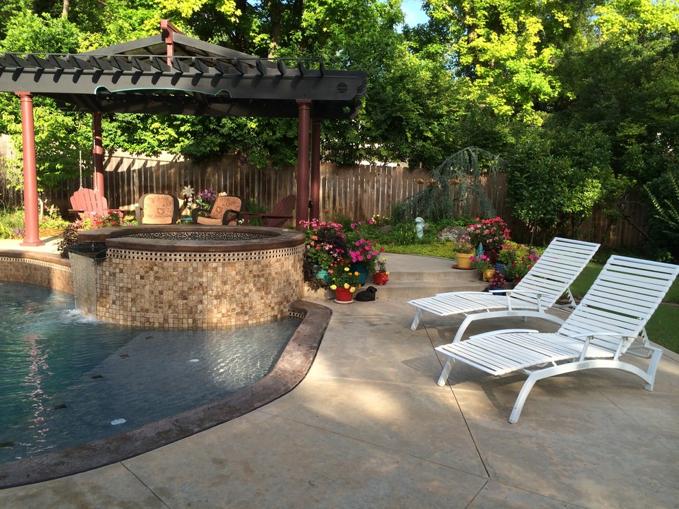 Mid-sized transitional backyard kidney-shaped natural pool in Oklahoma City with a hot tub and stamped concrete.