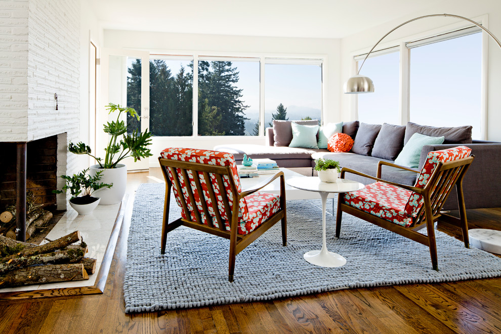Photo of a midcentury living room in Portland with white walls and medium hardwood floors.