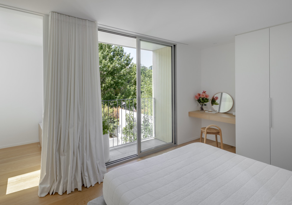 Exemple d'une chambre moderne avec un mur blanc, parquet clair et un sol beige.