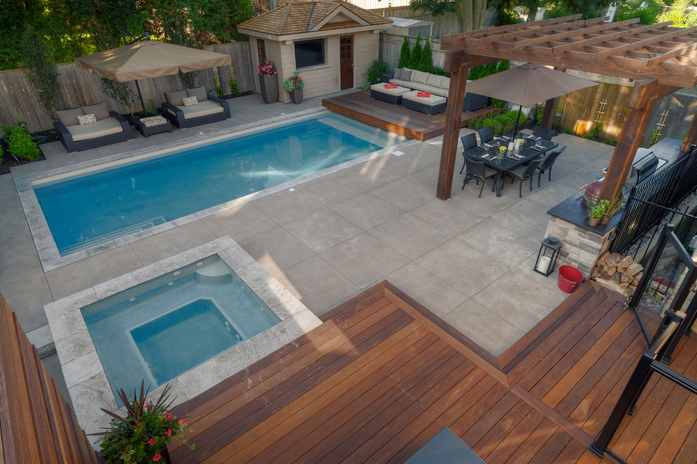 Photo of a large contemporary backyard rectangular lap pool in Toronto with a hot tub and concrete pavers.