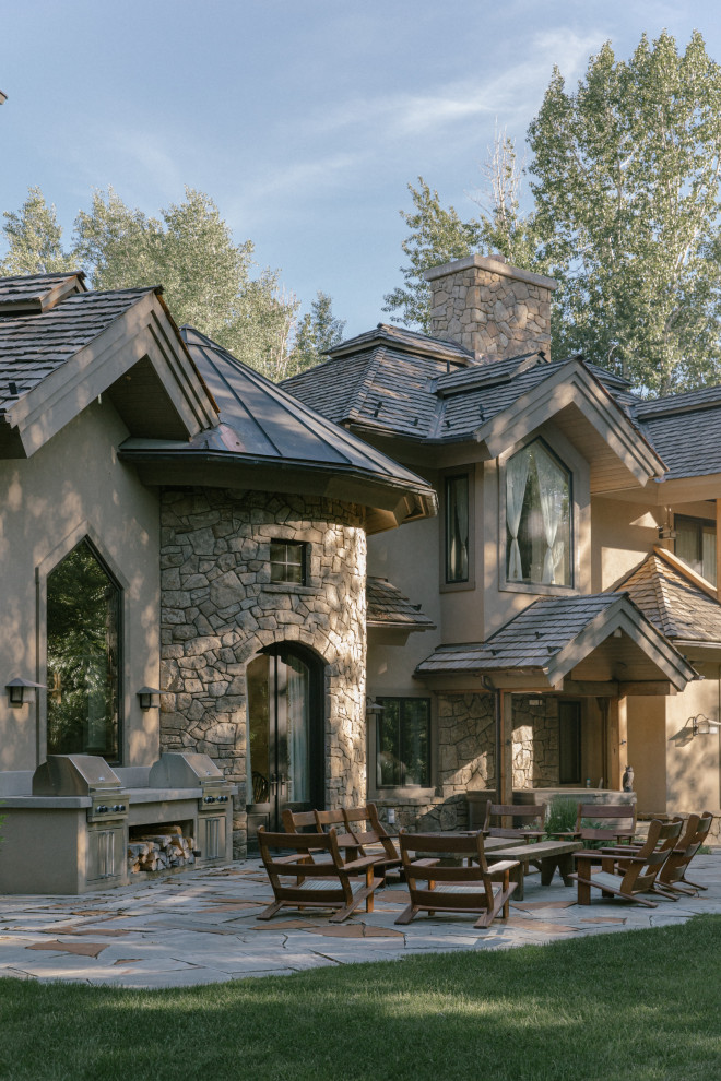 Idee per la villa marrone rustica a due piani con rivestimento in pietra, tetto a capanna, copertura a scandole e tetto marrone
