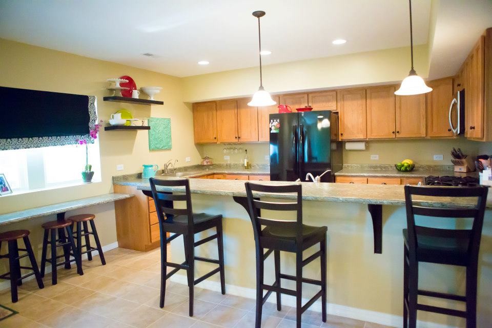 Example of a transitional u-shaped eat-in kitchen design in Chicago with a drop-in sink, flat-panel cabinets, medium tone wood cabinets and laminate countertops
