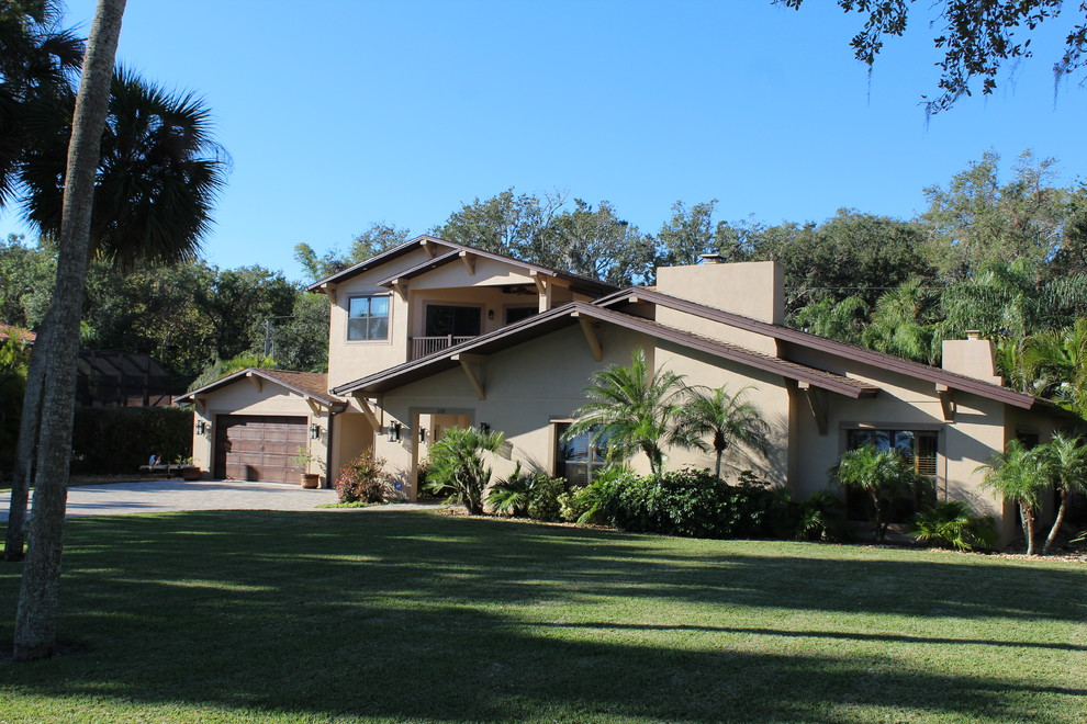 Large transitional beige two-story stucco gable roof photo in Orlando