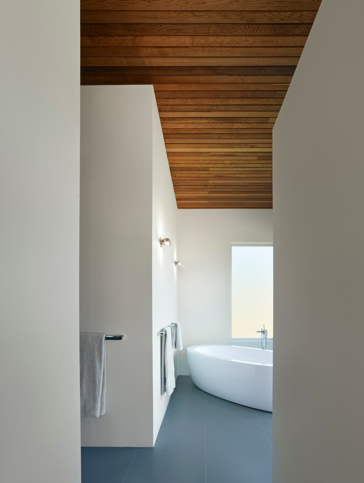 This is an example of a large contemporary master bathroom in San Francisco with a freestanding tub, white walls and porcelain floors.