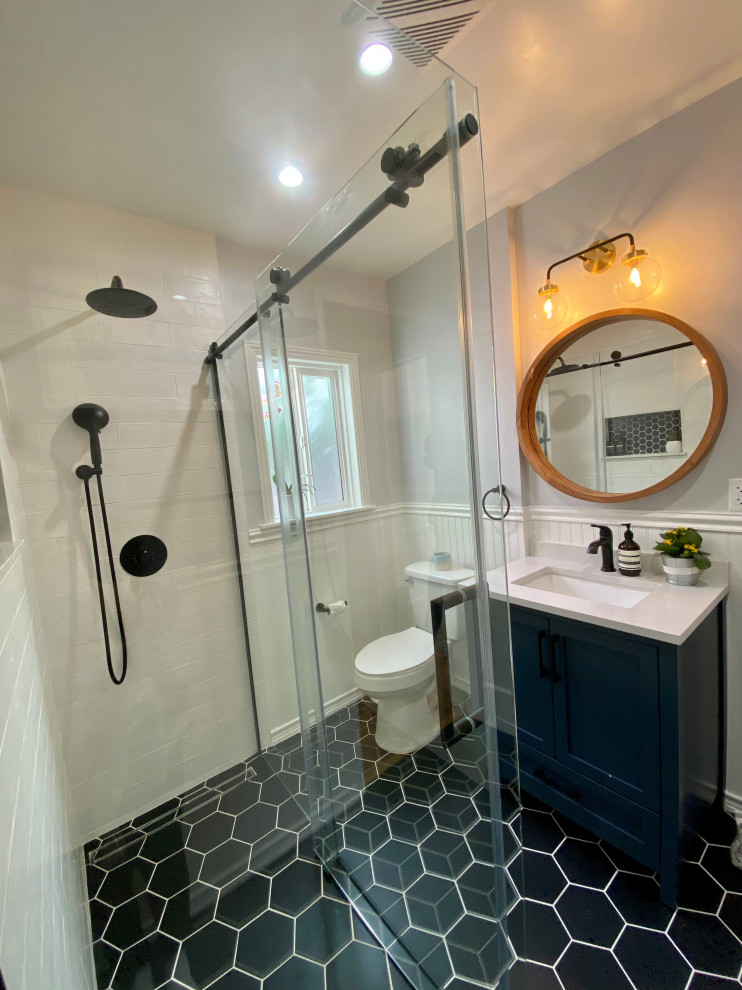 Источник вдохновения для домашнего уюта: ванная комната среднего размера в стиле ретро с фасадами в стиле шейкер, синими фасадами, душем без бортиков, раздельным унитазом, белой плиткой, керамической плиткой, белыми стенами, полом из керамической плитки, душевой кабиной, врезной раковиной, мраморной столешницей, черным полом, душем с раздвижными дверями, белой столешницей, нишей, тумбой под одну раковину, встроенной тумбой и панелями на стенах