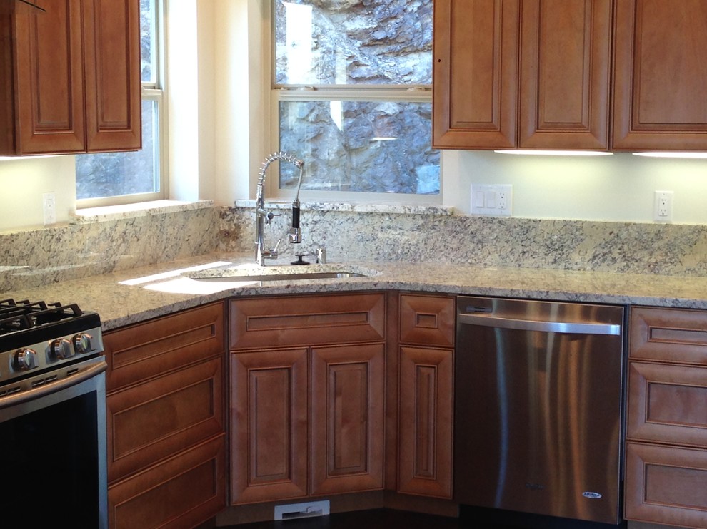 This is an example of a mid-sized arts and crafts u-shaped eat-in kitchen in Seattle with an undermount sink, light wood cabinets, granite benchtops, stone slab splashback, stainless steel appliances, raised-panel cabinets and beige splashback.