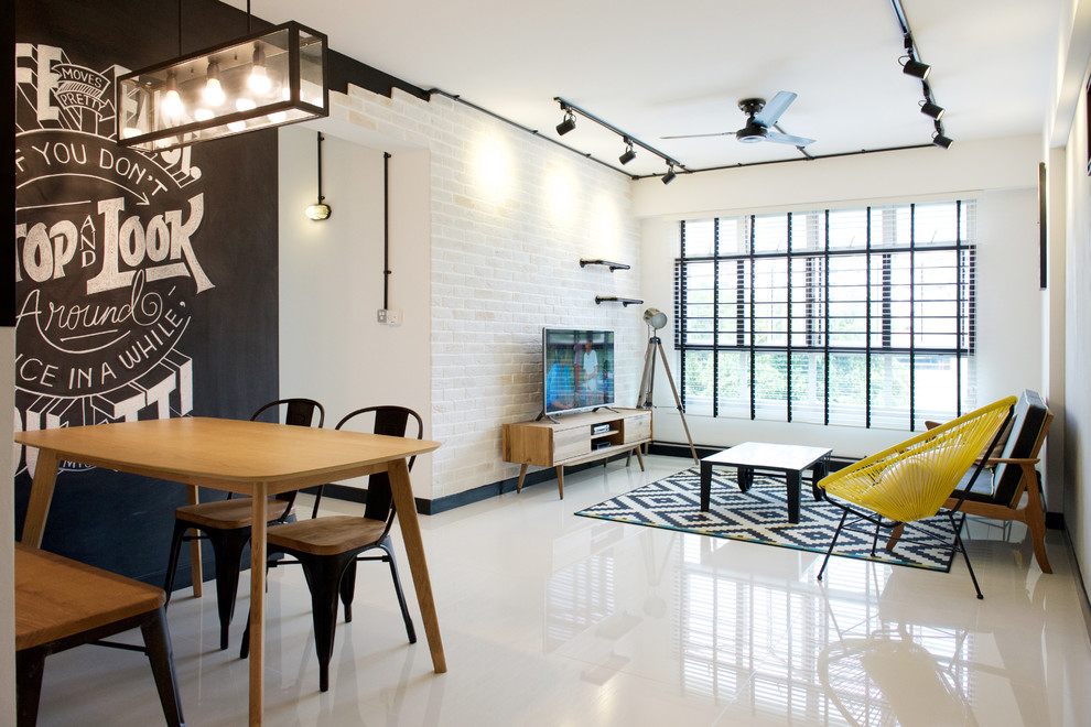 This is an example of an industrial open concept living room in Singapore with ceramic floors and a freestanding tv.
