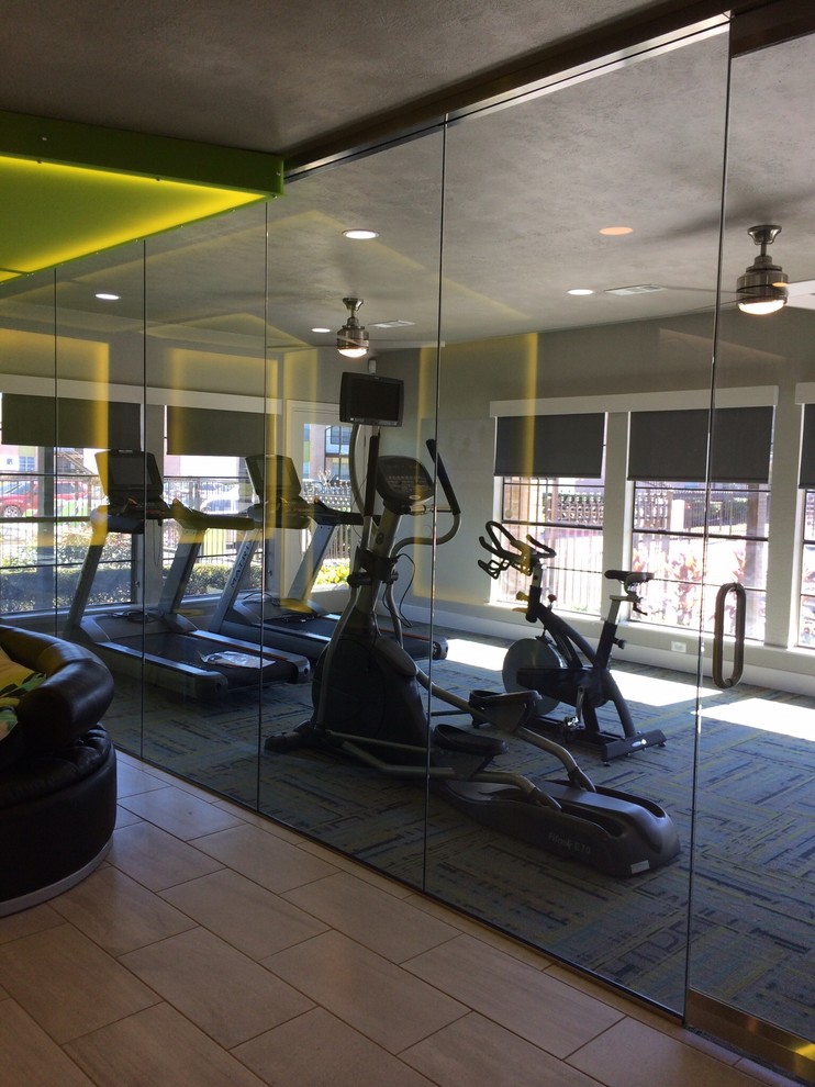 This is an example of a large eclectic multipurpose gym in Houston with grey walls and carpet.