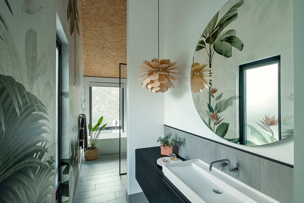 Design ideas for a mid-sized contemporary master bathroom in Perth with black cabinets, a freestanding tub, an open shower, gray tile, ceramic tile, white walls, ceramic floors, a vessel sink, laminate benchtops, grey floor, an open shower, black benchtops and flat-panel cabinets.