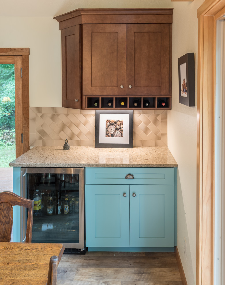 This is an example of a small transitional single-wall wet bar in Minneapolis with shaker cabinets, medium wood cabinets, granite benchtops, beige splashback, ceramic splashback, medium hardwood floors, brown floor and beige benchtop.