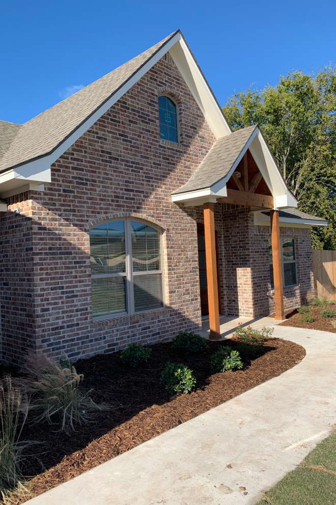 Mid-sized contemporary one-storey brick brown house exterior in Austin with a gable roof and a shingle roof.