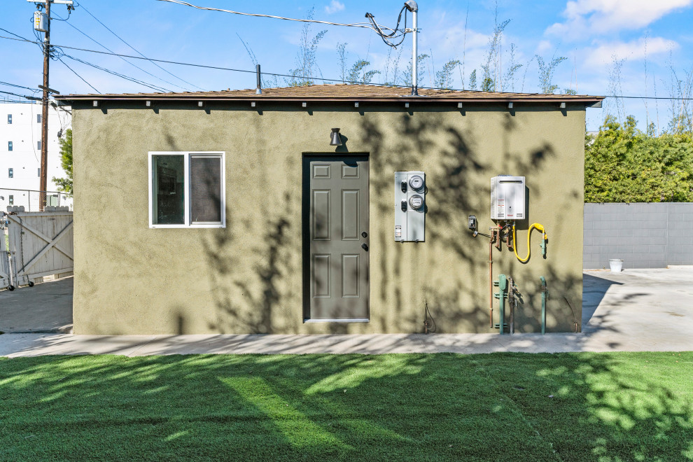 Mittelgroßes, Einstöckiges Modernes Tiny House mit gestrichenen Ziegeln, grüner Fassadenfarbe, Flachdach, Schindeldach, grauem Dach und Schindeln in Los Angeles