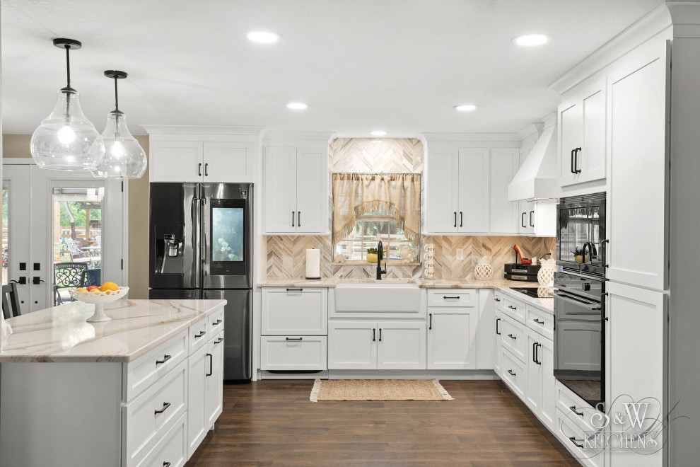 Mid-sized farmhouse l-shaped vinyl floor and brown floor eat-in kitchen photo in Tampa with a farmhouse sink, shaker cabinets, white cabinets, quartz countertops, beige backsplash, marble backsplash, black appliances, an island and beige countertops
