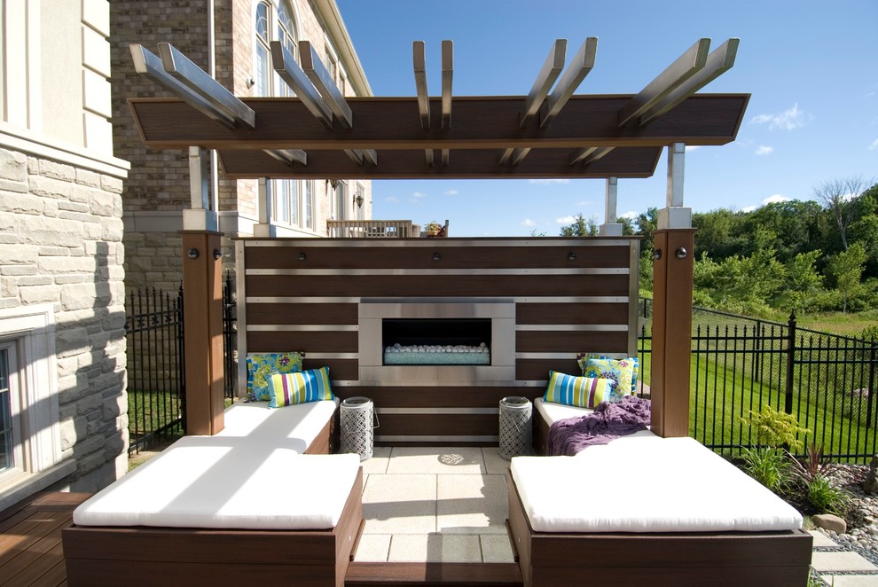 Design ideas for a large contemporary backyard deck in Toronto with a fire feature and a pergola.