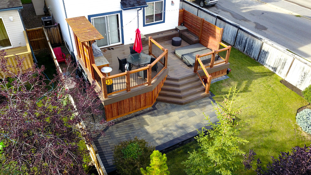 Photo of a large traditional backyard deck in Calgary with an outdoor kitchen and a pergola.