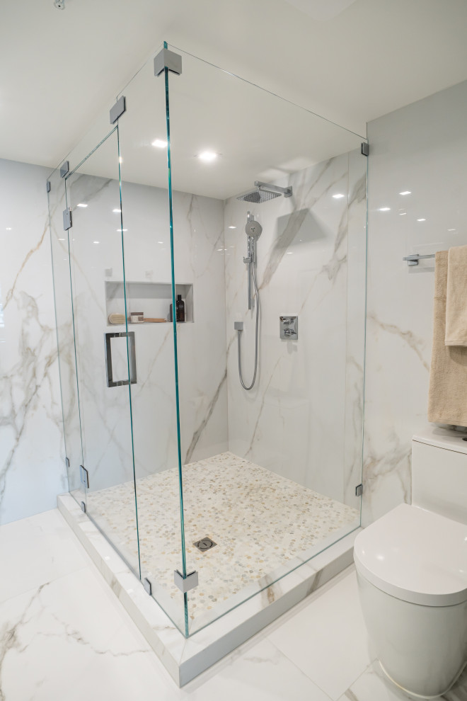 Photo of a large modern 3/4 bathroom in Miami with flat-panel cabinets, white cabinets, a corner shower, a one-piece toilet, multi-coloured tile, stone slab, multi-coloured walls, porcelain floors, an undermount sink, engineered quartz benchtops, multi-coloured floor, a hinged shower door, grey benchtops, a niche, a double vanity and a floating vanity.