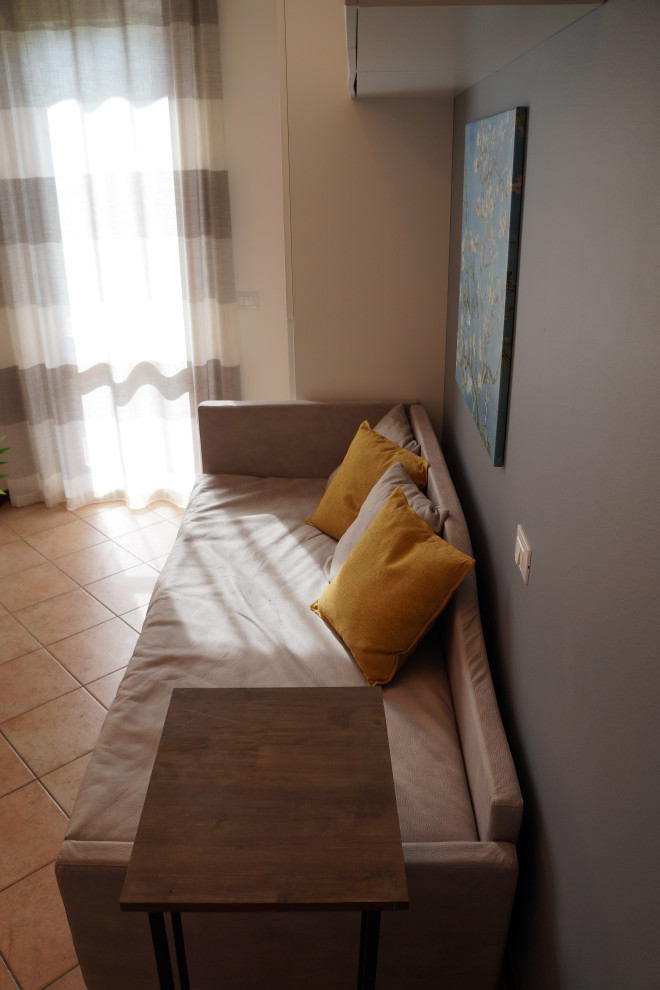 Foto de habitación de invitados contemporánea pequeña con paredes grises, suelo de ladrillo y suelo rojo