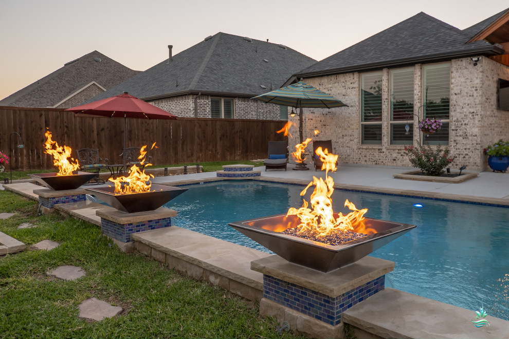 Large midcentury backyard custom-shaped natural pool in Dallas with a hot tub and concrete slab.