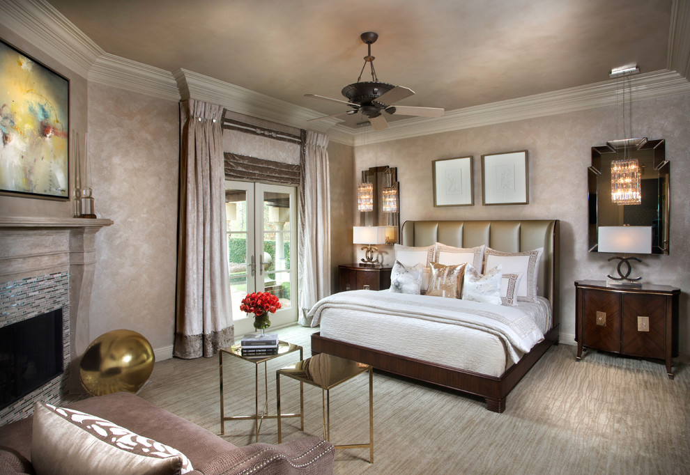Transitional master bedroom in New Orleans with beige walls, carpet, a corner fireplace, a tile fireplace surround and beige floor.
