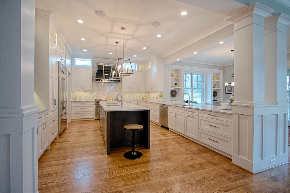 This is an example of a large transitional u-shaped kitchen in DC Metro with recessed-panel cabinets, white cabinets, granite benchtops, white splashback, mosaic tile splashback, stainless steel appliances, medium hardwood floors and with island.